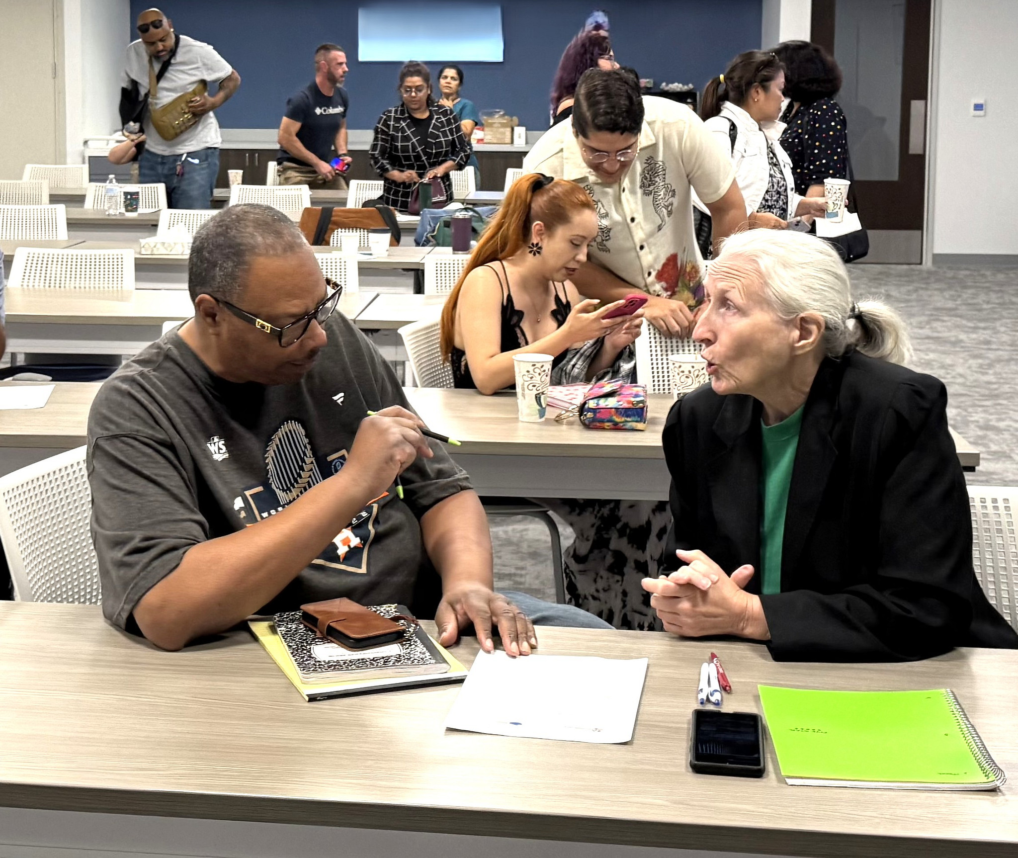 Two people have a conversation in a classroom setting during a small business class.