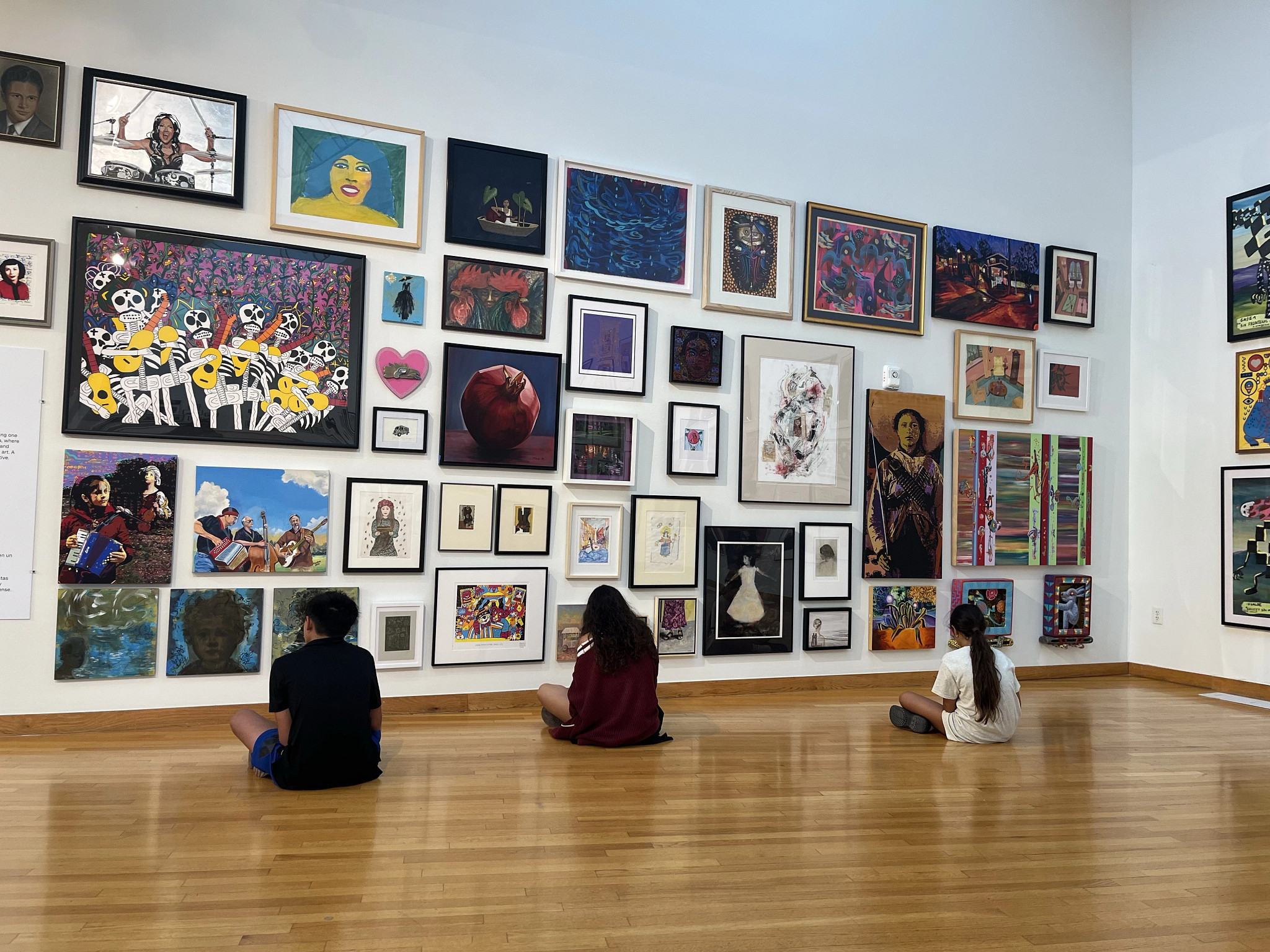 Youth in front of paintings in a gallery indoors