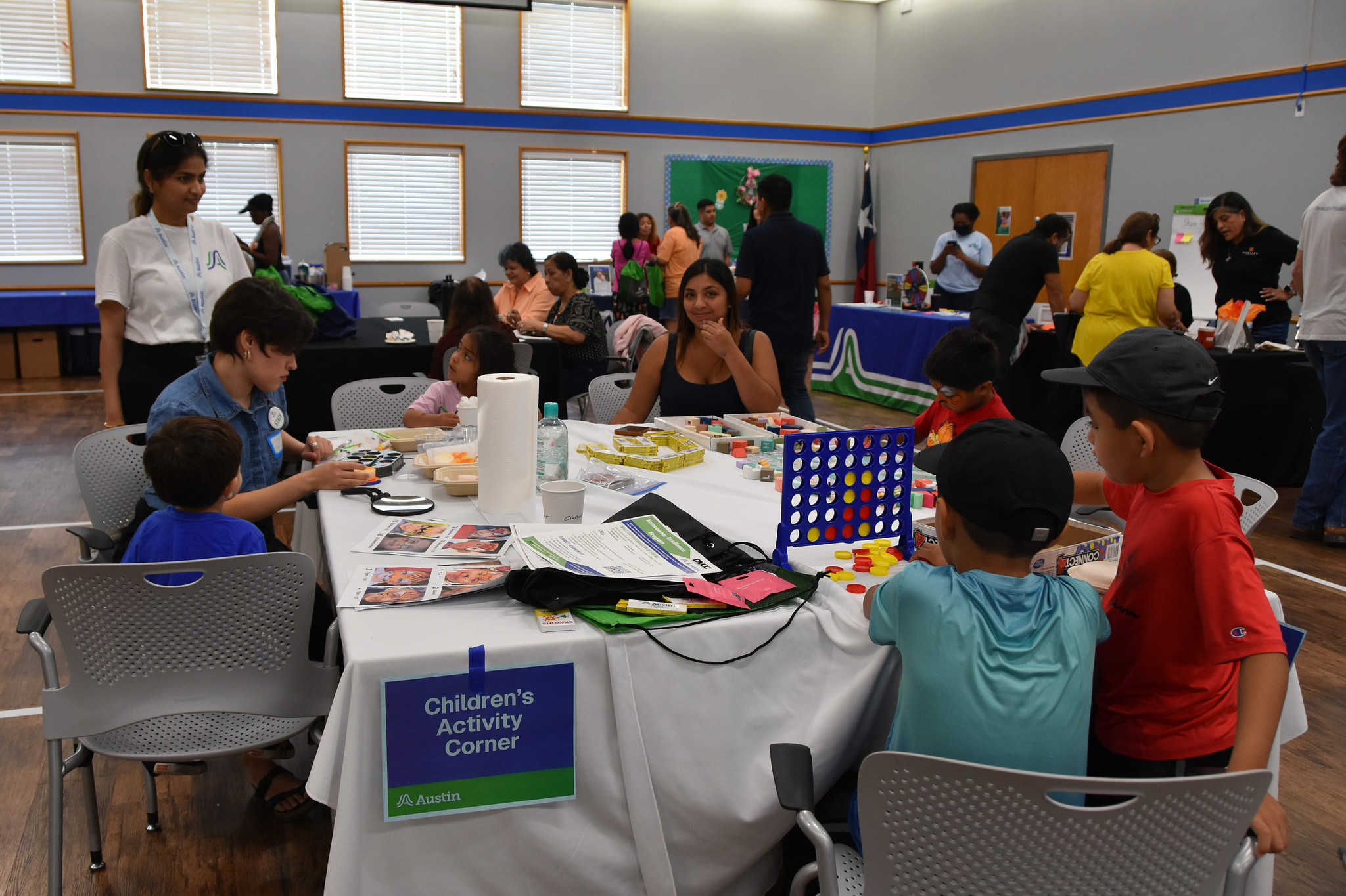 Image shows children of area residents playing at an activity table while their families receive resources at the affordable housing fair.
