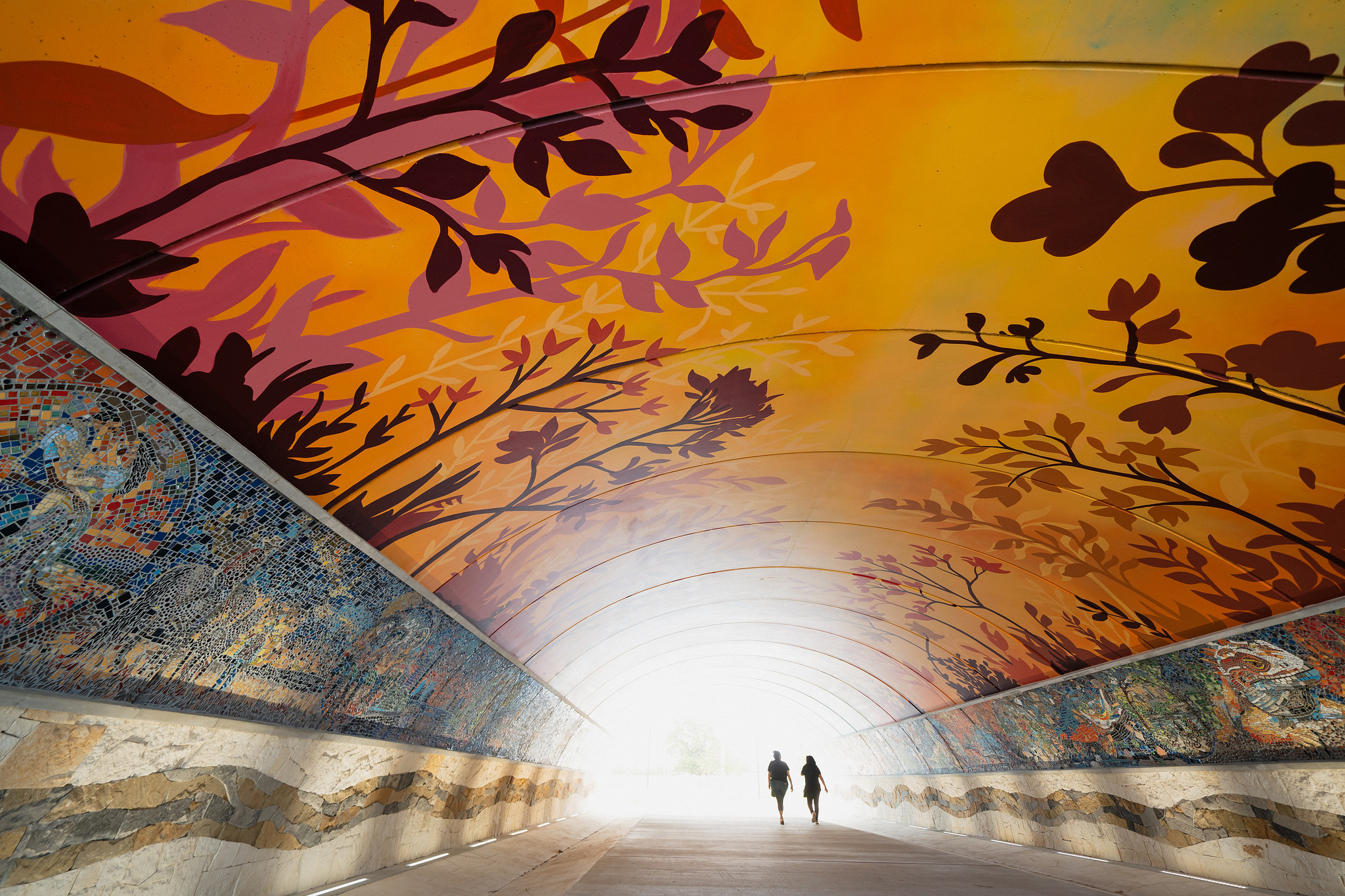 Two people walking through the Absolute Equality Unity Tunnel