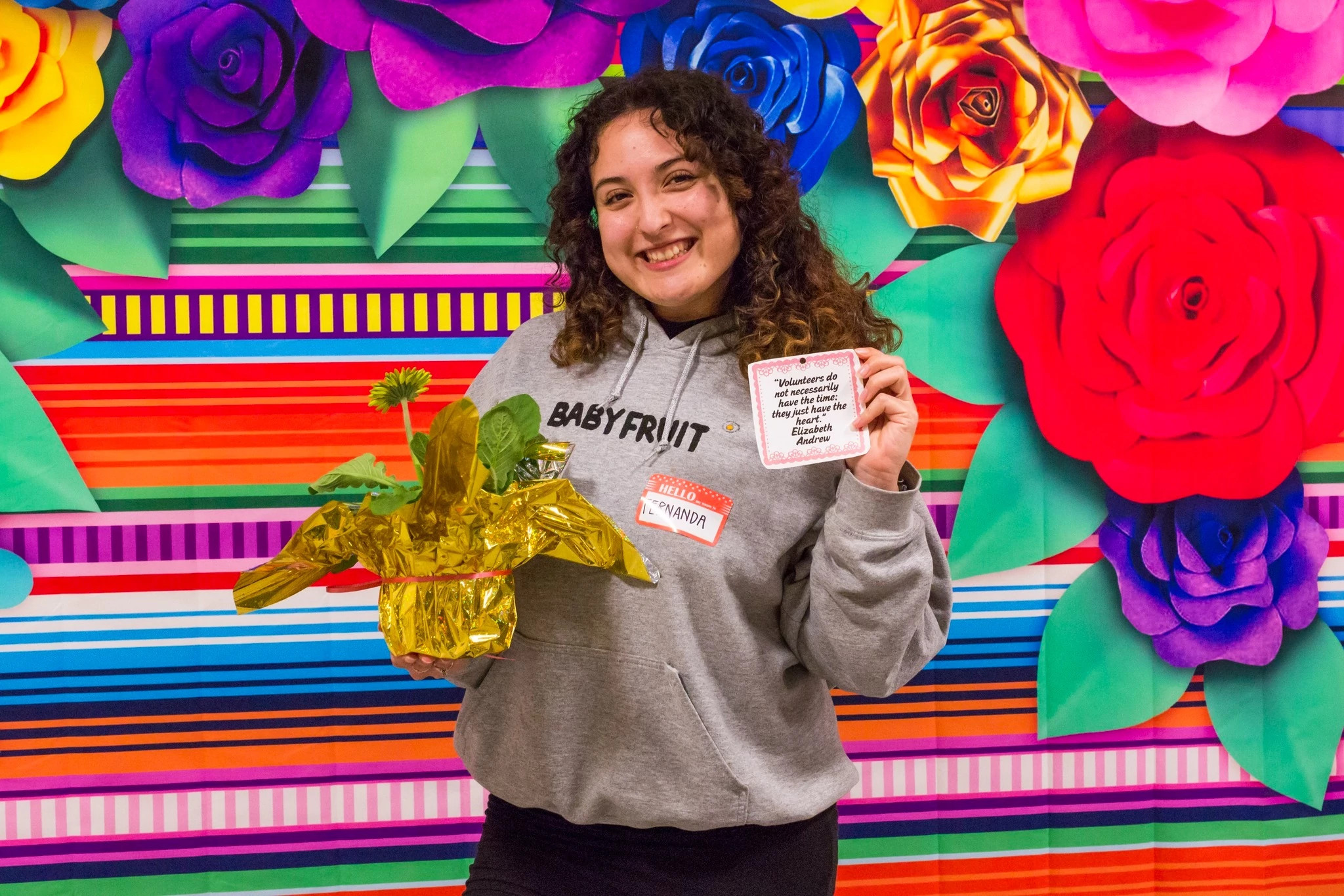 Smiling volunteer in front of a rainbow background