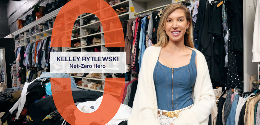 Kelley Rytlewski stands next to a large pile of clothes and in front of stocked shelves. A graphic reads, Kelley Rytlewski, Net-Zero Hero.