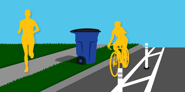 A person jogging on the sidewalk, a trash cart in the grass buffer strip between the sidewalk and the street, and a cyclist riding a bike in the bike lane.