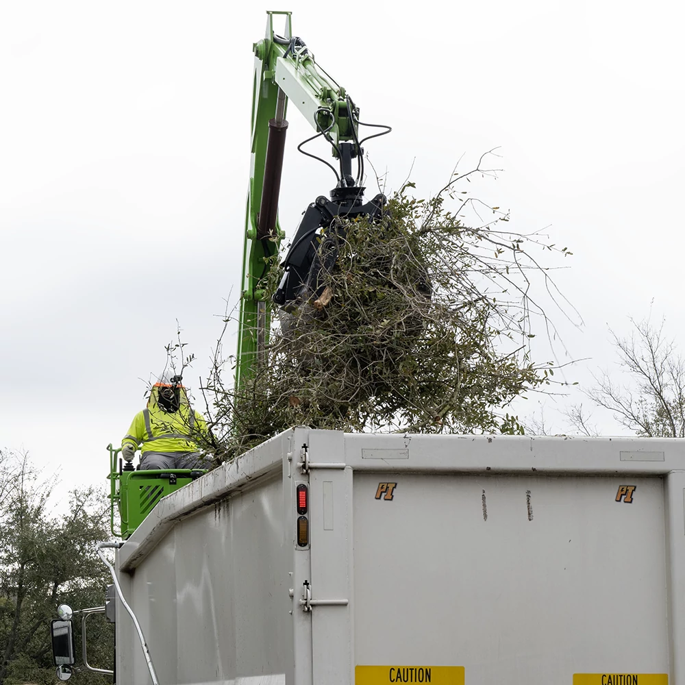 Large brush is being collected on-demand by an Austin Resource Recovery crane truck.