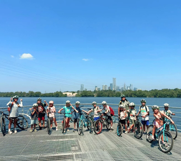 Group of kids on bikes with the lake behind them