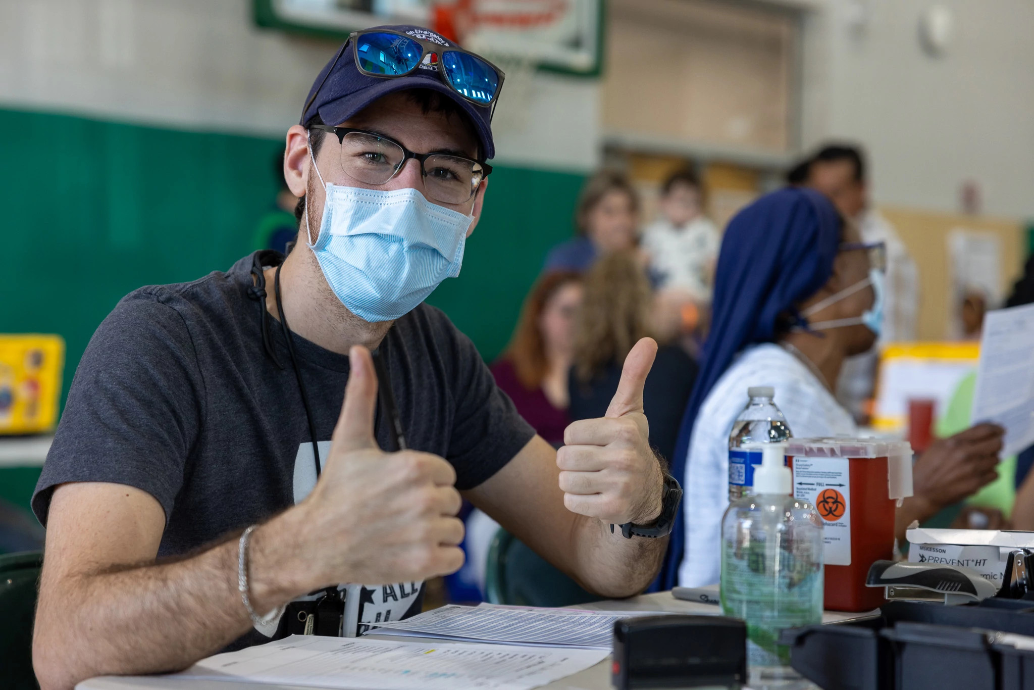 A photo showing an Austin Public Health nurse giving two thumbs up at a vaccination event.