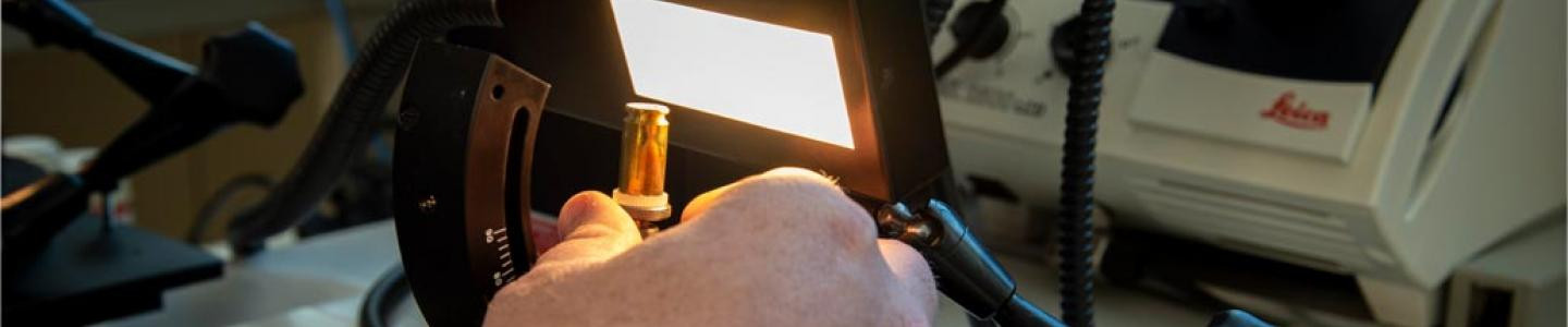 Banner with hands holding forensic equipment