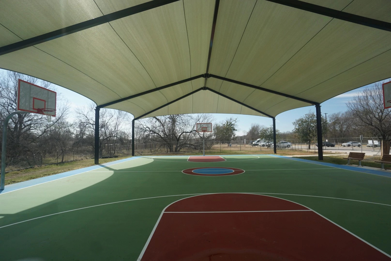 Outdoor, shaded basketball court at Roy G. Guerrero Park
