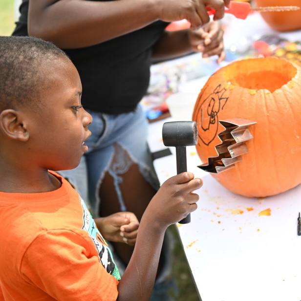 Child carving pumpkin