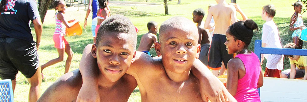 two boys posing for a photo while participating in a splash day