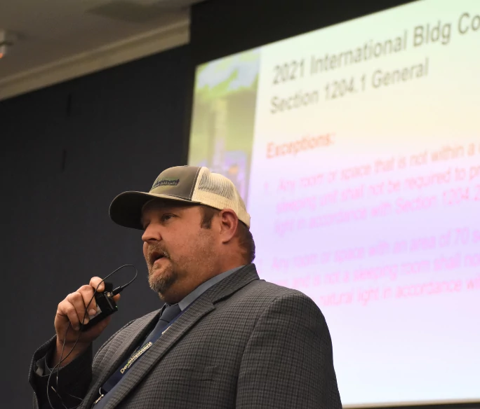 Person talking into microphone standing in front of presentation
