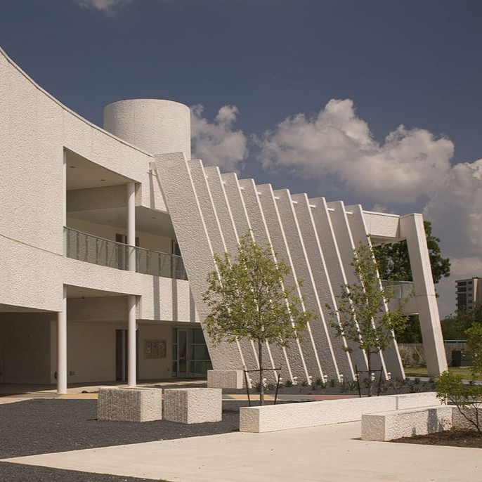 Exterior of the Emma S. Barrientos MACC featuring white textured walls and pillars.