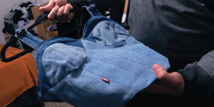 A close up of Billy holding a top he made from repurposed denim pants.