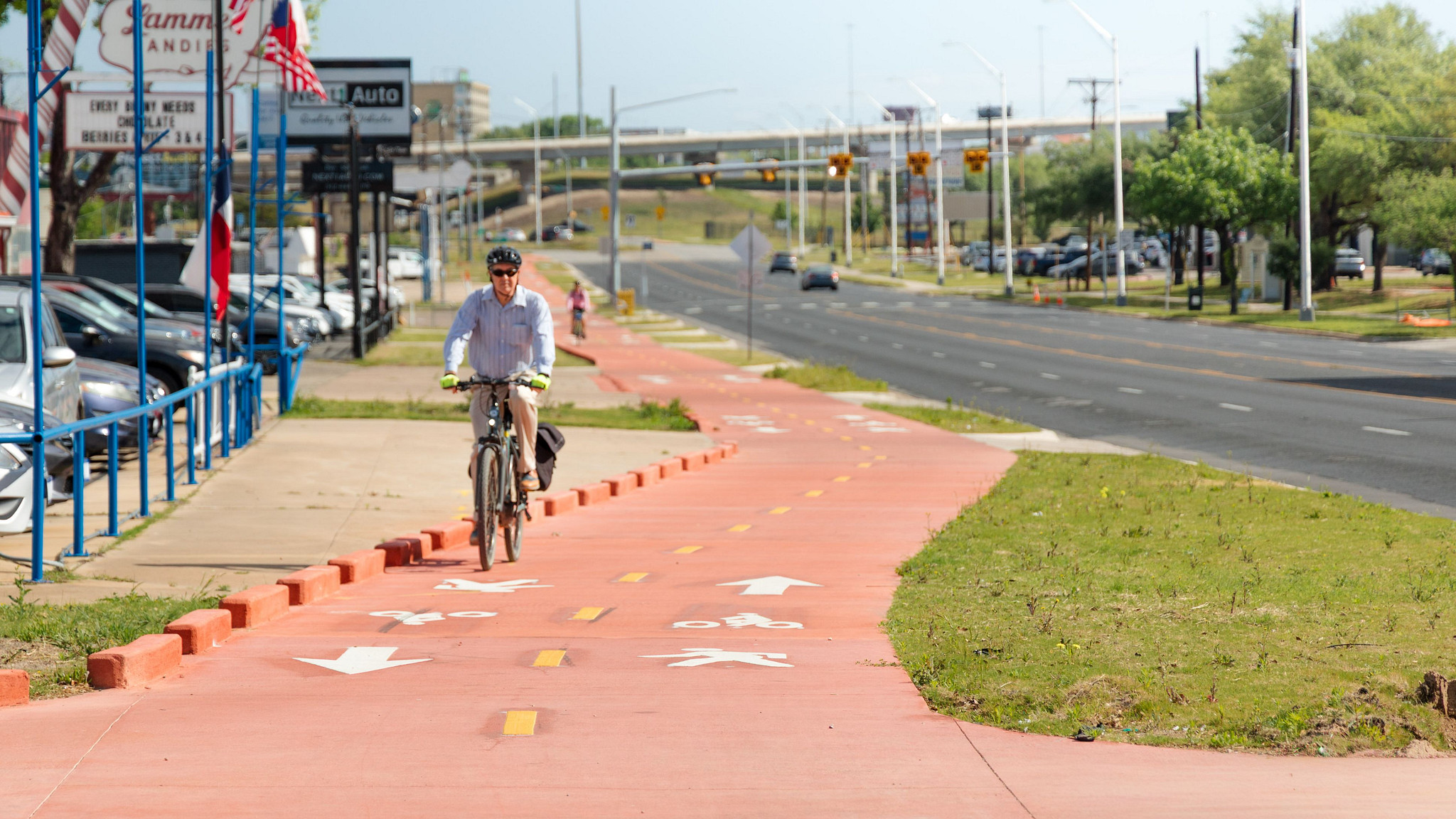Person riding a bicycle on a shared-use path along Airport Boulevard.