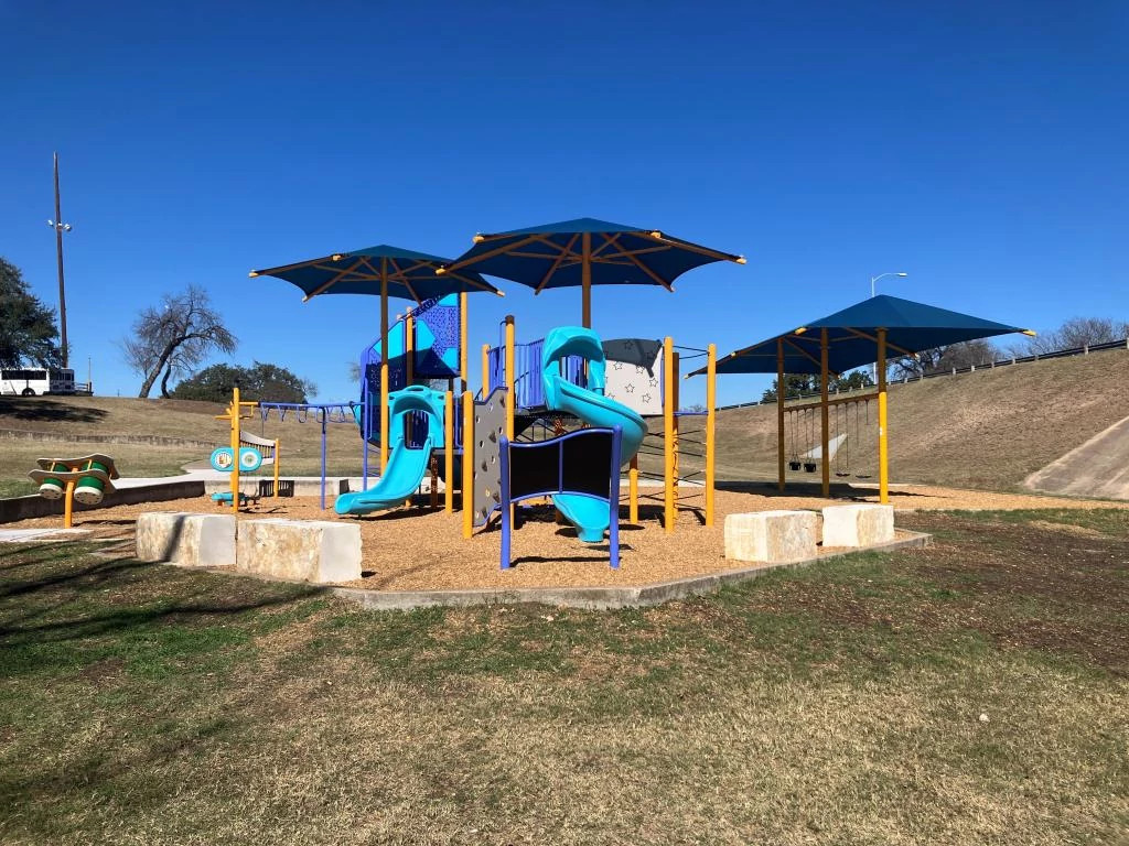 New playground at Rosewood includes slides, swings, a climbing wall and multiple shade structures.