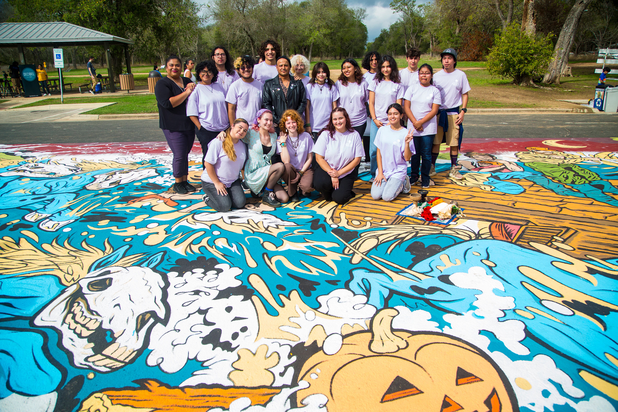 A group of people standing on top of a mural on asphalt