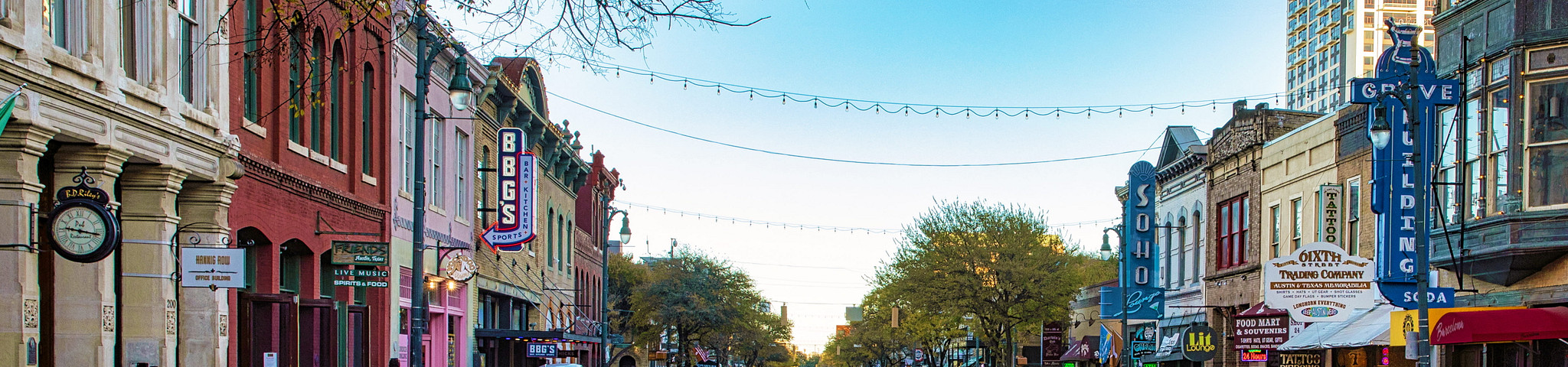 View of East 6th Street featuring buildings, signs, and lights.