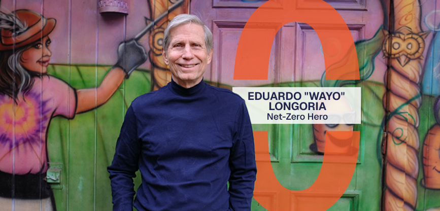 Wayo stands smiling in front of a mural at Casa de Luz. Text reads, Eduardo 'Wayo' Longoria, Net-Zero Hero.