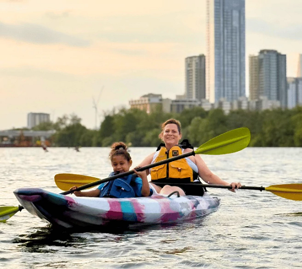 mother and daughter in a kayak on Lady Bird Lake at evening
