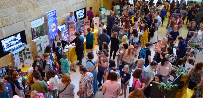 The Atrium at Austin City Hall is filled with people as students present at an EcoRise Innovation Showcase.
