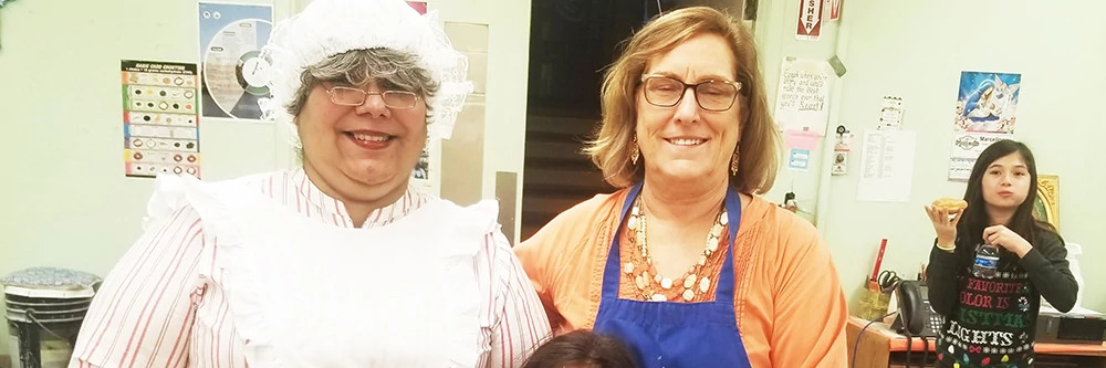 Older adult and woman in Ms Claus costume together