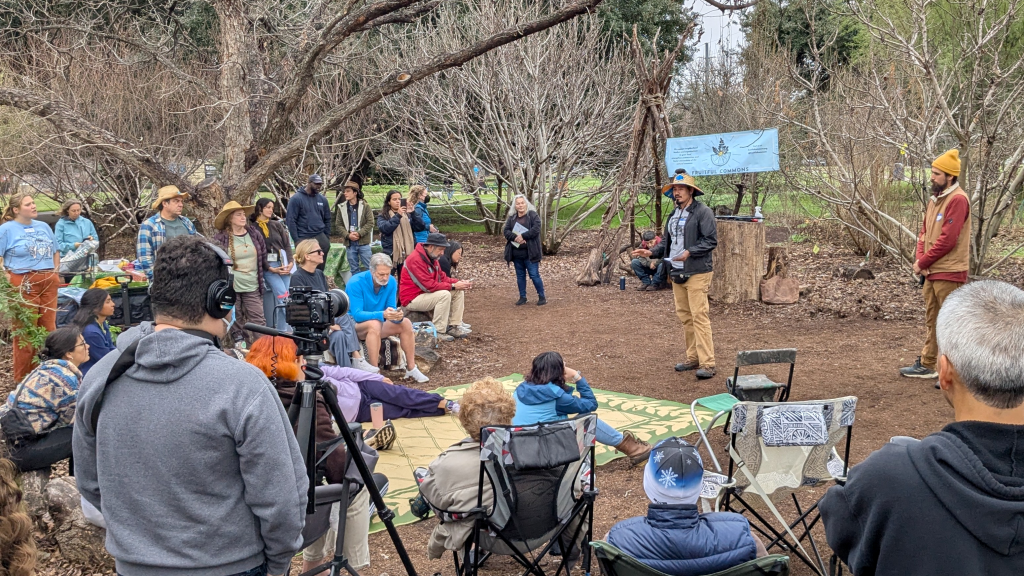 An instructor speaks to people at an outdoor tree health worskhop