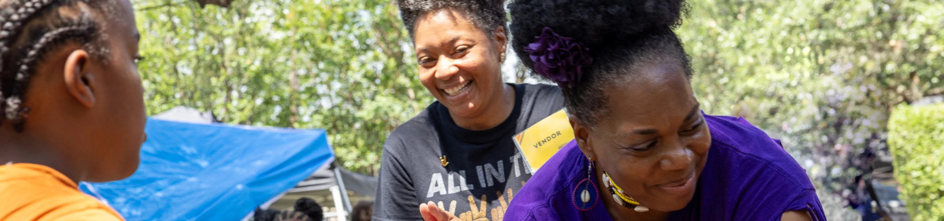 Banner with two women smiling working at an Austin Public Health event