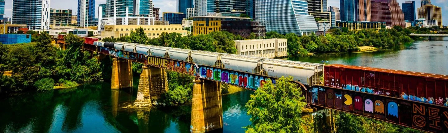 Banner showing the train bridge with colorful street art across Colorado River in Austin, TX