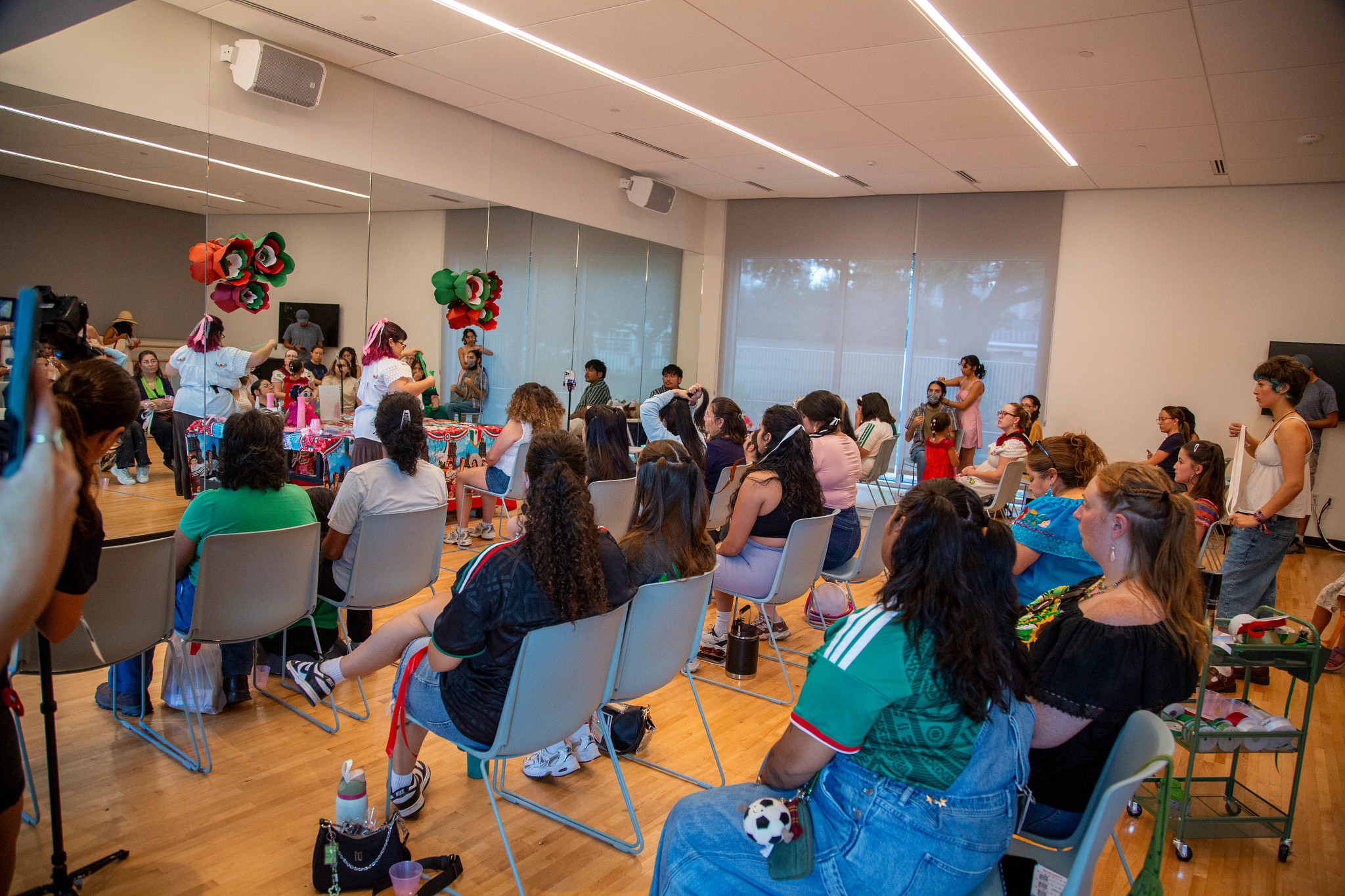 hair braiding workshop in a wooden floor dance studio with windows and mirror walls