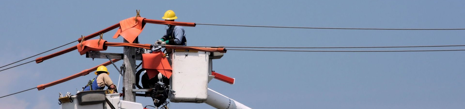Banner with workers fixing an electricity line.