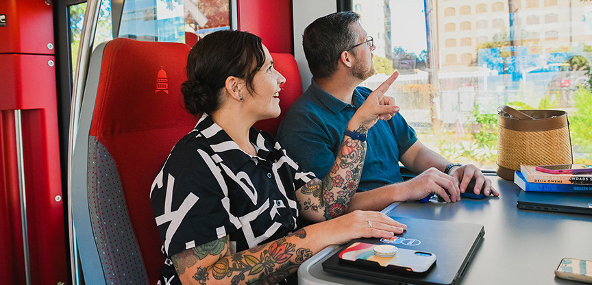 Photo of two people commuting to work on a city train.