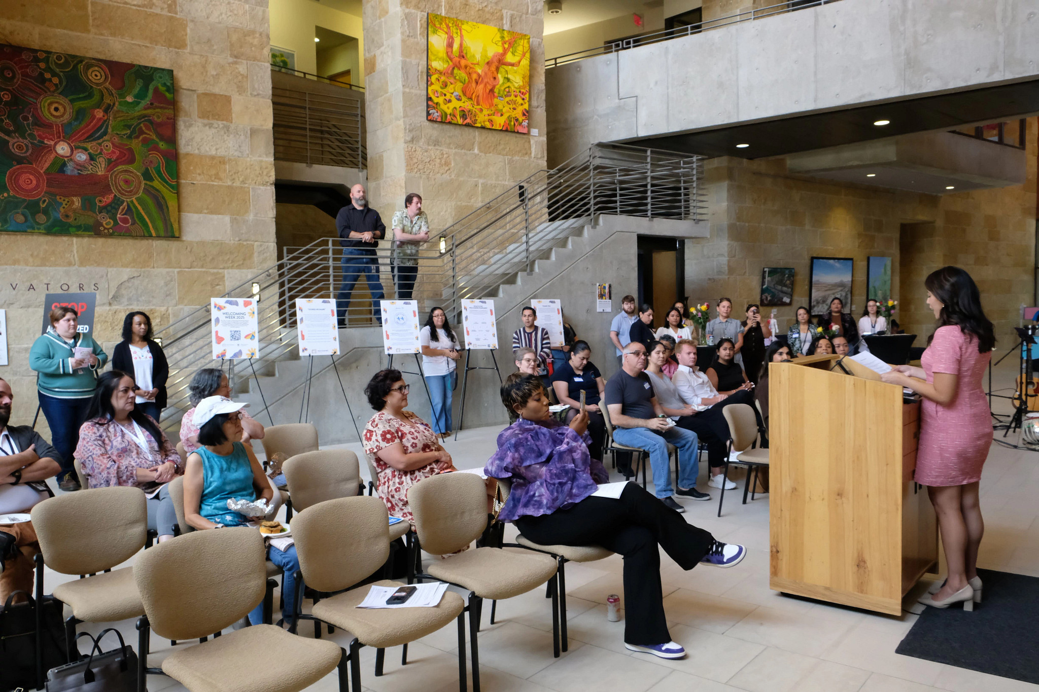 Councilmember Vanessa Fuentes stands at a podium in City Hall Library sharing the Welcoming Week Proclamation to the audience