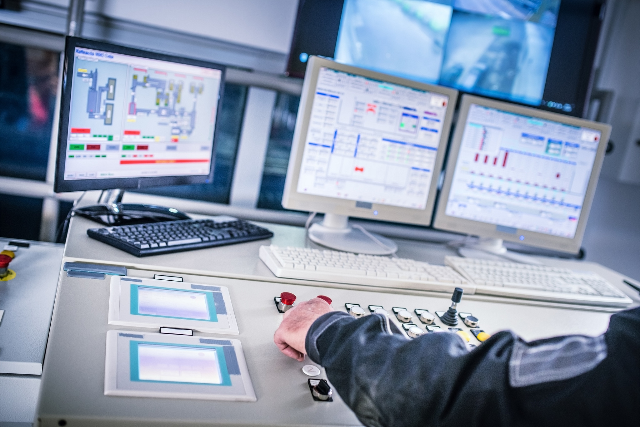 Finger on emergency button in control room.