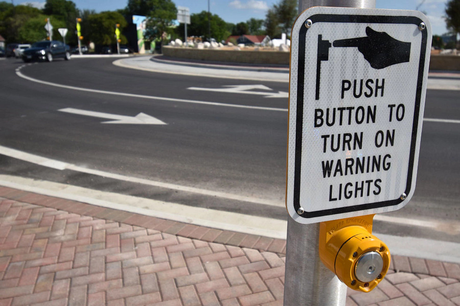 A pedestrian hybrid beacon in front of a roundabout