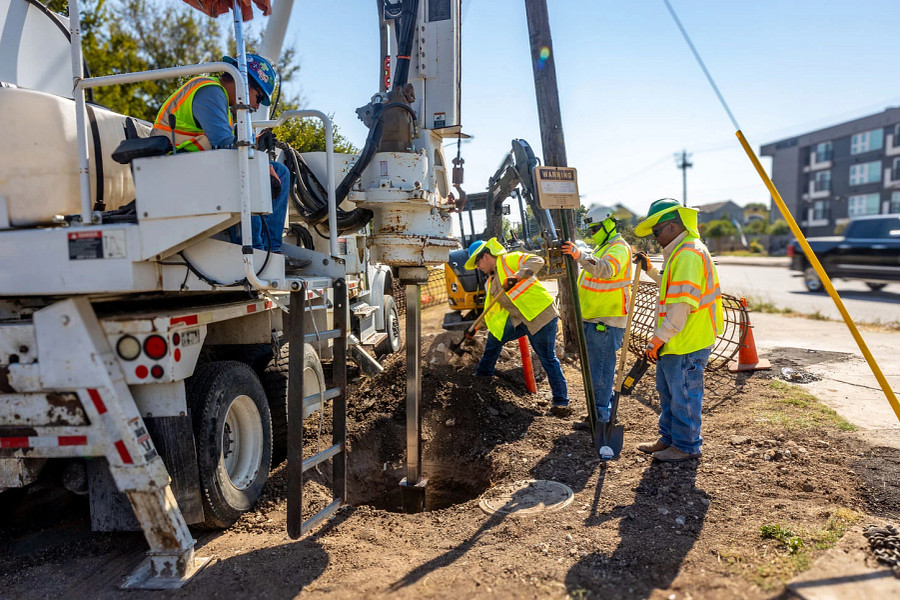 A construction crew installing traffic signal infrastructure