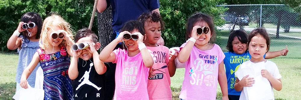 youth looking through homemade binoculars