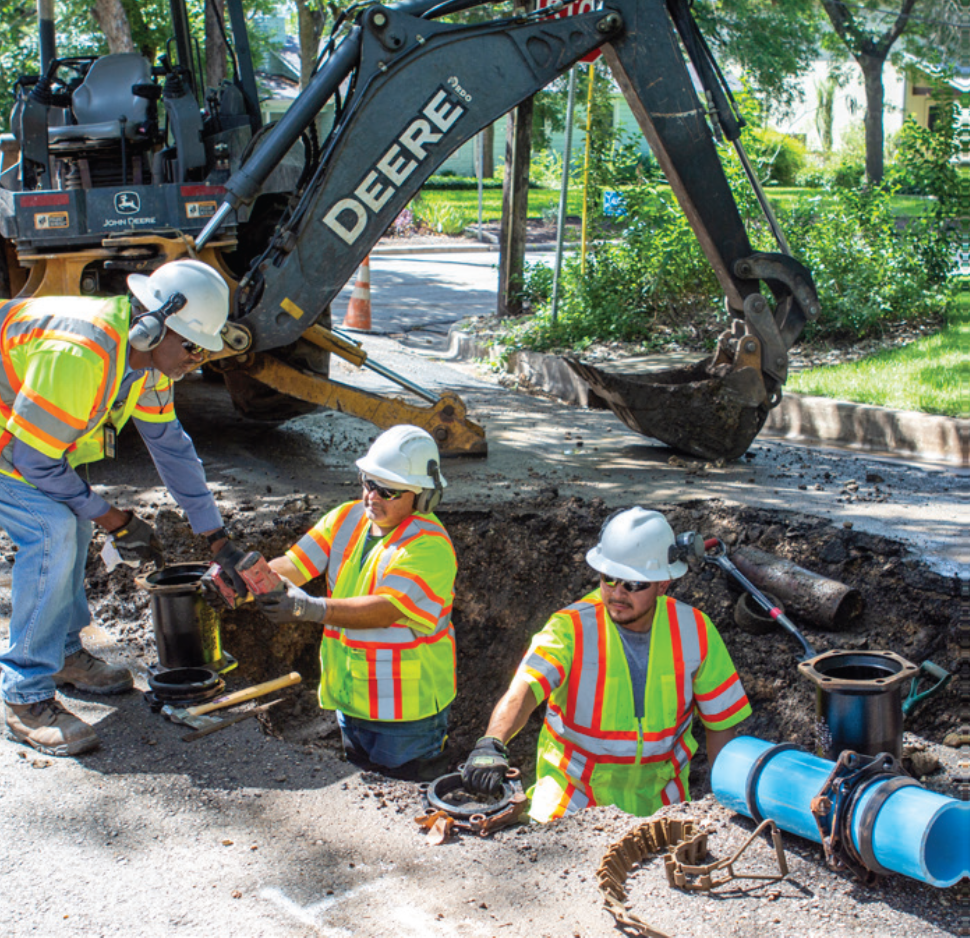 A group of Austin Water workers excavating an underground pipe.