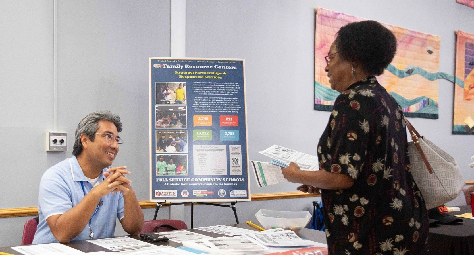 A member of the community speaking to staff at a resource fair for Community Initiated Solutions, one of the City programs aiming to prevent displacement. 