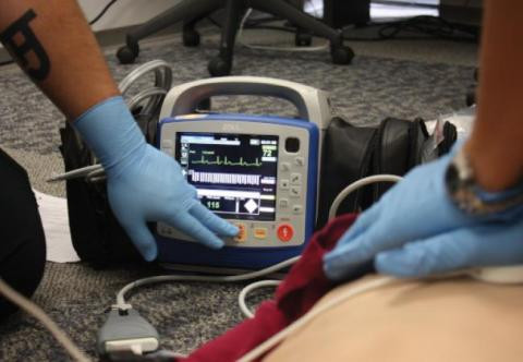 EMS cadets using a defibrillator on a body during training