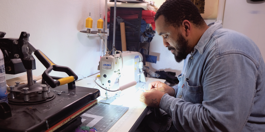 Billy works on a garment at his home studio.