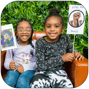 Two kids holding up protest signs at Carver Black History Month Kids Day