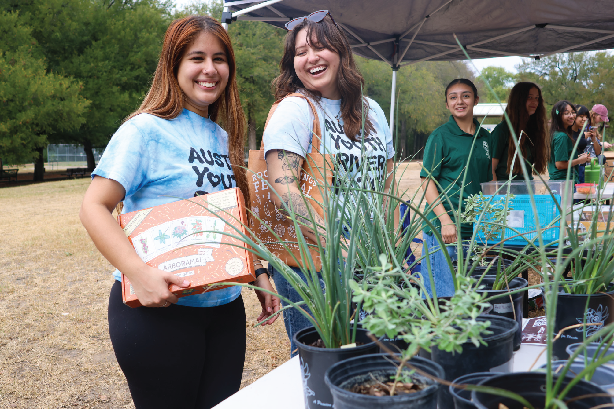 Image of ladies laughing and plants at a Roots and Wings Festival community event.