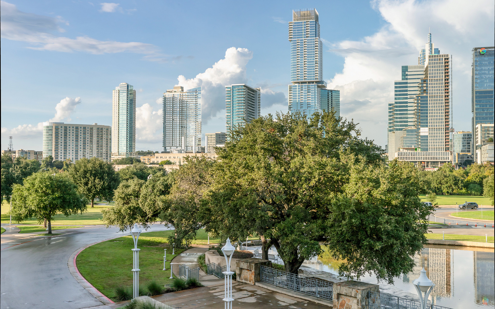 View from Palmer Events Center balcony of trees, pond, and Downtown Austin skyline