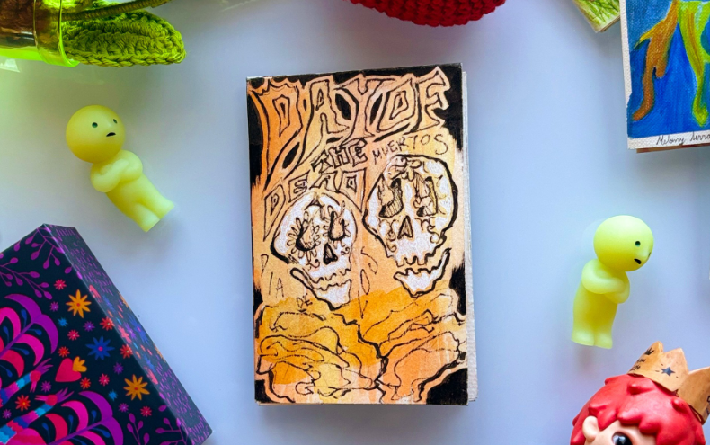 Folded mini-booklet that says Dia de los Muertos on the cover