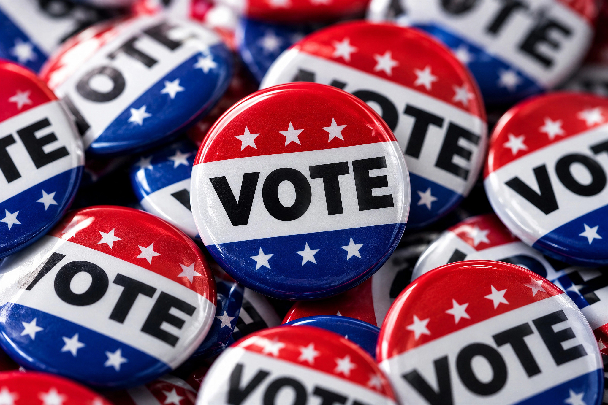 a pile of political election buttons say vote