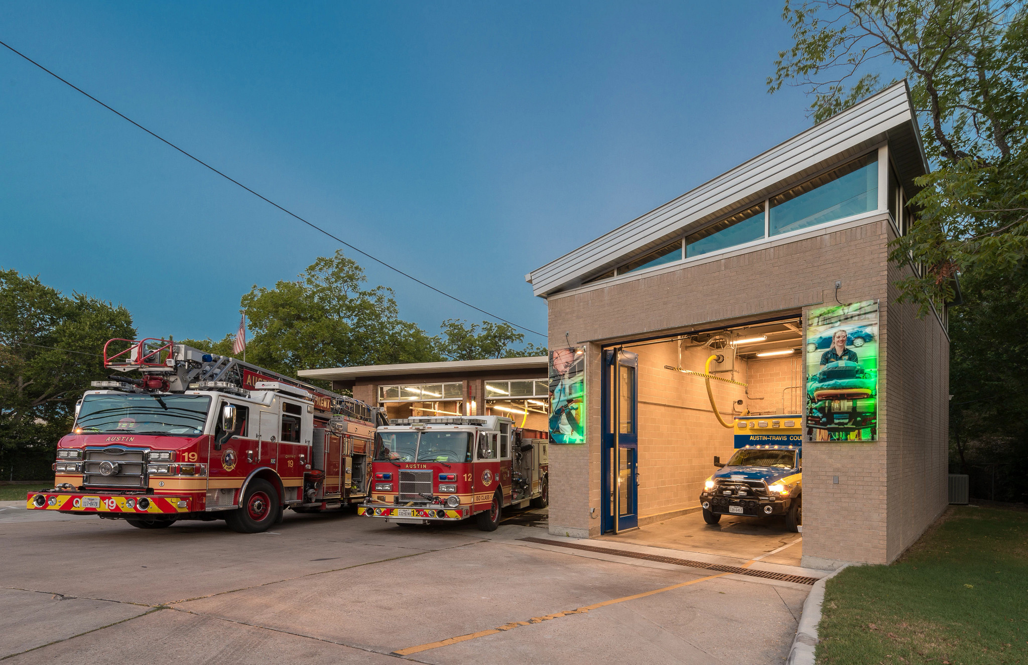 A picture of 2 firetrucks and an ambulance parked at a fire station.