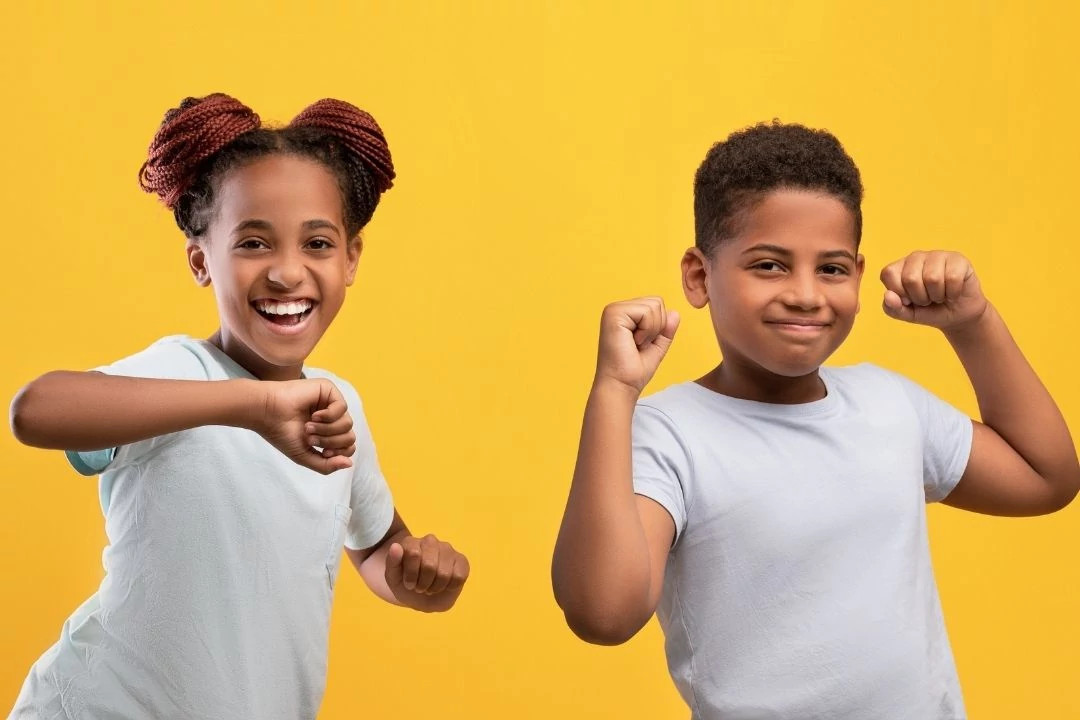 Two children dancing against a yellow background