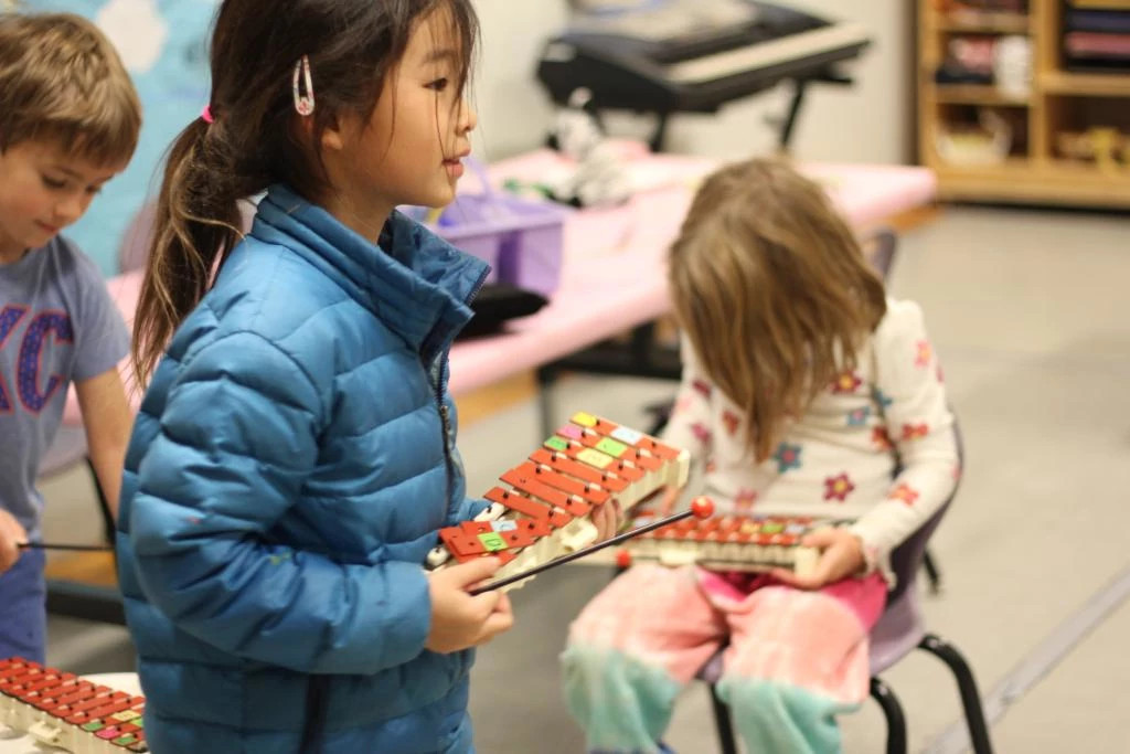 youth engage in music activity using glockenspiels