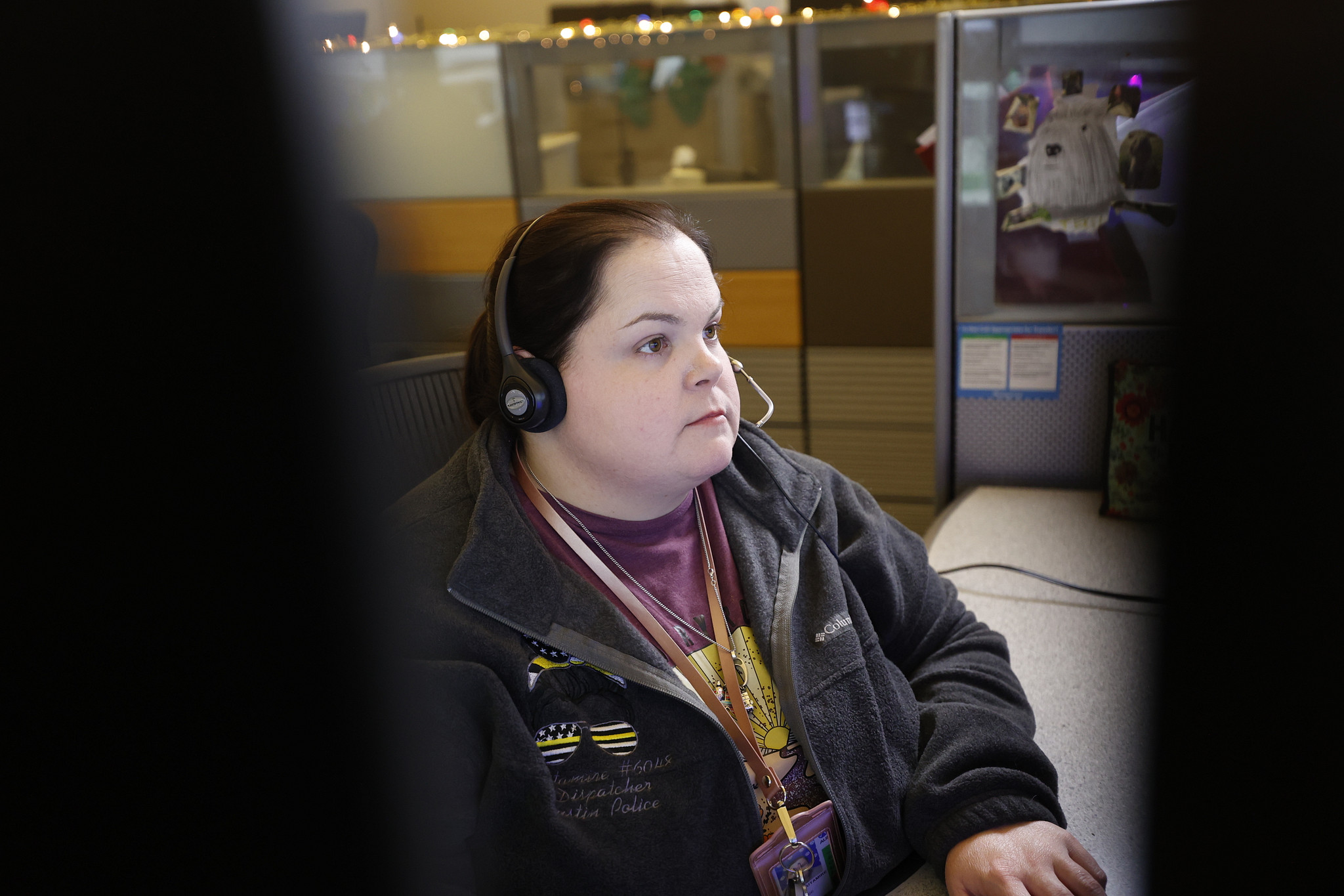 An Austin Police Dispatcher wearing a headset while working at their desk.