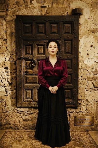 ESB MACC Viva Mexico Samantha stnading in front of old wooden door in red and black dress